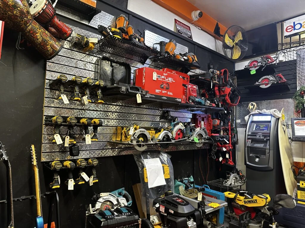 Wall of cordless drills, circular saws and power tools inside the shop